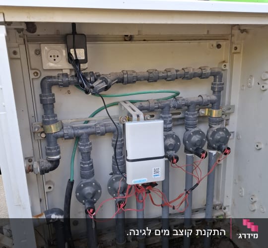 מערכת השקיה עם צינורות ושסתומים בגינה
